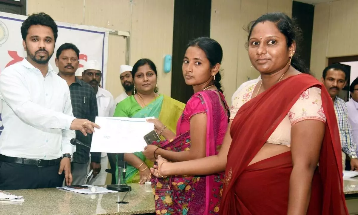 District Collector Prasanna Venkatesh handing over sanctioned documents to the petitioners at Spandana programme in Eluru on Monday