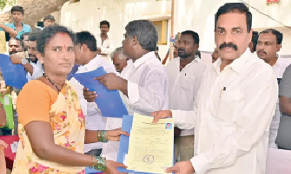 Agriculture Minister Kakani Govardhan Reddy distributing house site patta to a beneficiary at Nakkala Colony in Chemudugunta village on Sunday