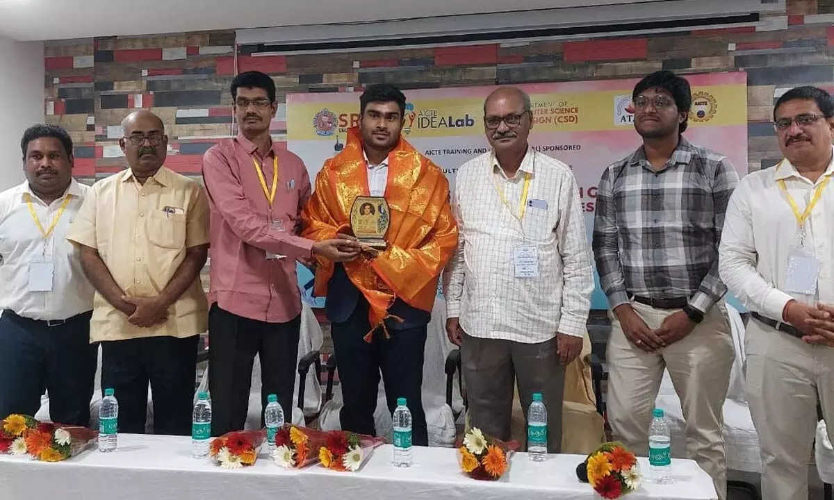 SRKR Engineering College Director Dr M Jagapati Raju felicitating M Pavan Kumar Varma, founder of Carry-Care Solutions, at the College in Bhimavaram on Monday