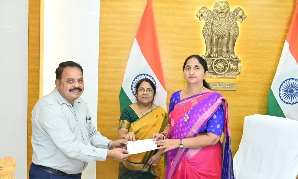 District Collector K Madhavi Latha handing over a cheque to Sainik Welfare Officer Dr Satya Prasad at a programme in Rajamahendravaram on Monday. MEPMA Project Director Priyamvada is also seen.