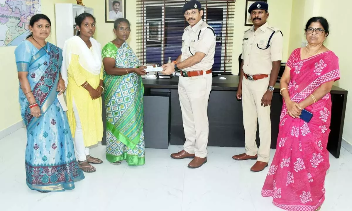 Superintendent of police K V Murali Krishna handing over a cheque of Rs 3.87 lakh to the victim’s family members in Anakapalli on Tuesday