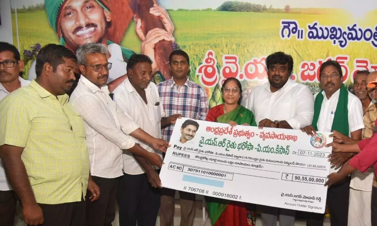 Nellore Zilla Parishad chairman Anam Arunamma along with Collector M Harinarayanan presenting the cheque to farmers under YSR Rythu Bharosa - PM Kisan scheme in Nellore on Tuesday