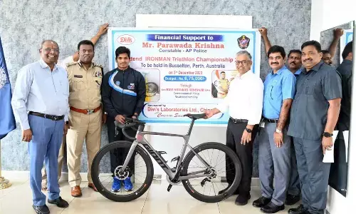 Representatives of Divi’s Laboratories presenting a bicycle to constable Parawada Krishna in Visakhapatnam on Saturday