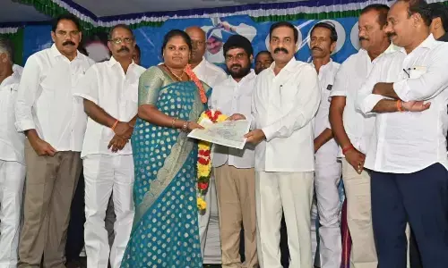 Agriculture Minister Kakani Govardhan Reddy distributing land ownership right pattas to a farmer at Molakalapudi village on Saturday