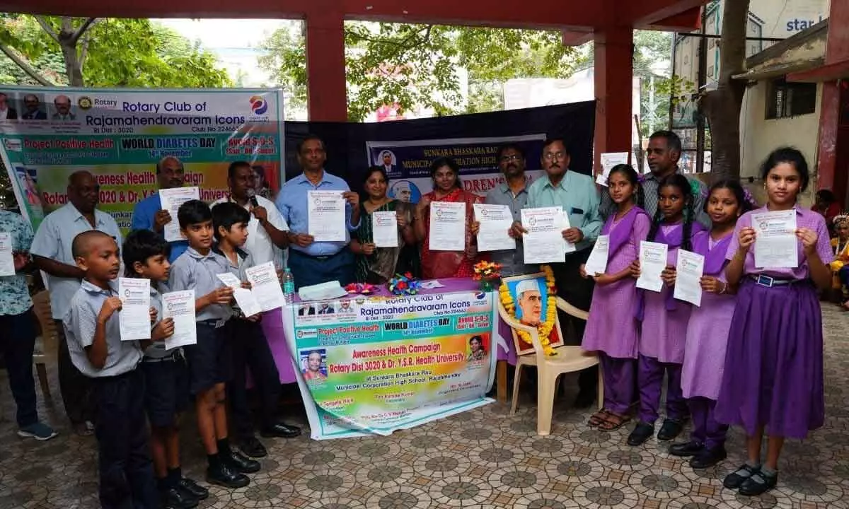 Students displaying health sheets provided by Rotary Club of Rajamahendravaram Icons on Thursday