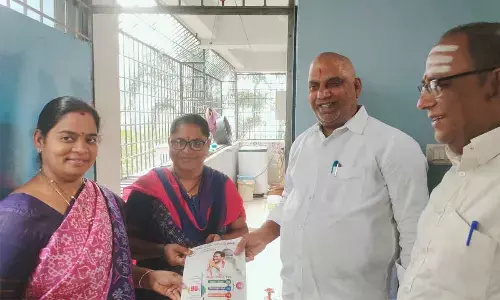 MLA Malladi Vishnu distributing YSRCP booklet to a resident in 58th division during the Gadapa Gadapaku programme in Vijayawada on Thursday