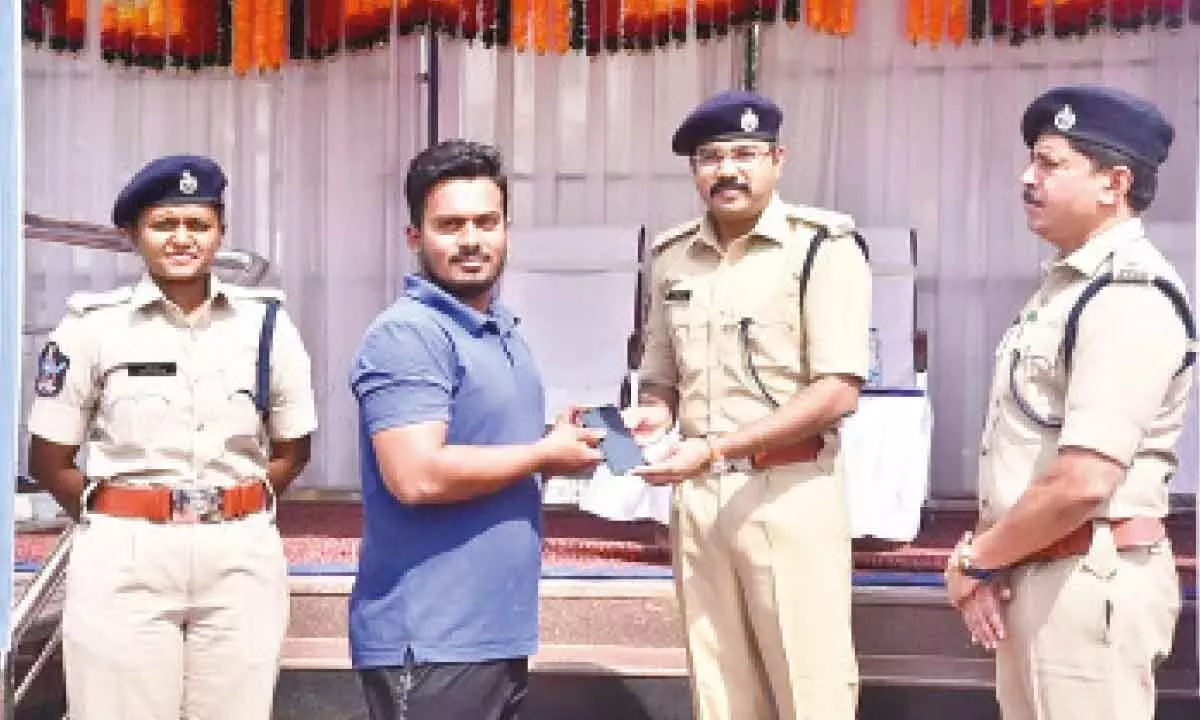 Superintendent of Police G Krishnakanth handing over a recovered mobile to its owner at police parade grounds in Kurnool on Sunday