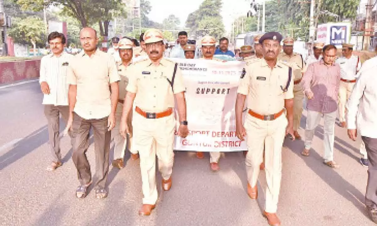 Deputy Transport Commissioner Sk Kareem, DSP M Bala Sundaram, APSRTC regional manager M Ravinkanth, and others participating in the walkathon in Guntur on Sunday