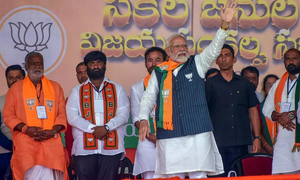 Prime Minister Narendra Modi waves to supporters during a public meeting at Maheshwaram ahead of Telangana Assembly elections, in Ranga Reddy district on Saturday