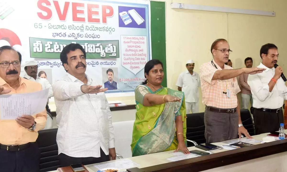 Collector B Lavanyaveni administering voter pledge for students at an awareness programme in Eluru on Tuesday