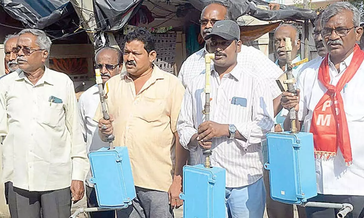CPM activists led by party leader Ch Babu Rao displaying the removed water meters at the 29th division in Vijayawada on Saturday