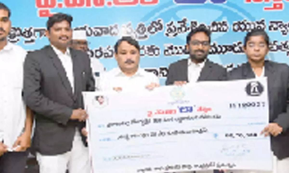 Joint Collector K Srinivasulu presenting YSR Law Nestham assistance to law graduates in Ongole on Monday