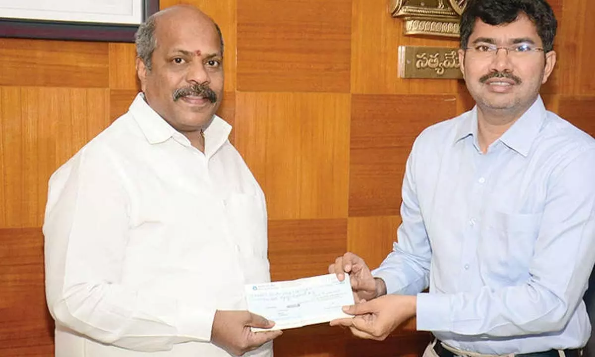 CMR Group CMD Mavuri Venkata Ramana handing over a cheque for Rs 4.80 lakh to district collector A Mallikarjuna in Visakhapatnam on Tuesday