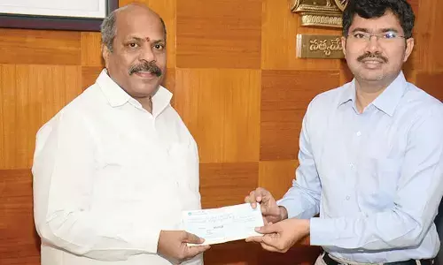 CMR Group CMD Mavuri Venkata Ramana handing over a cheque for Rs 4.80 lakh to district collector A Mallikarjuna in Visakhapatnam on Tuesday