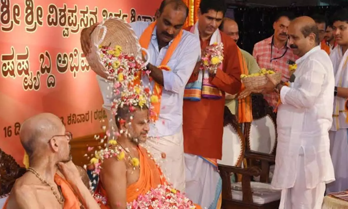 Udupi MLA Yashpal Suvarna showering flower petals on Sri Vishwaprasanna Theertha Swamiji, with former MLA of Udupi, K Raghupathi Bhat,