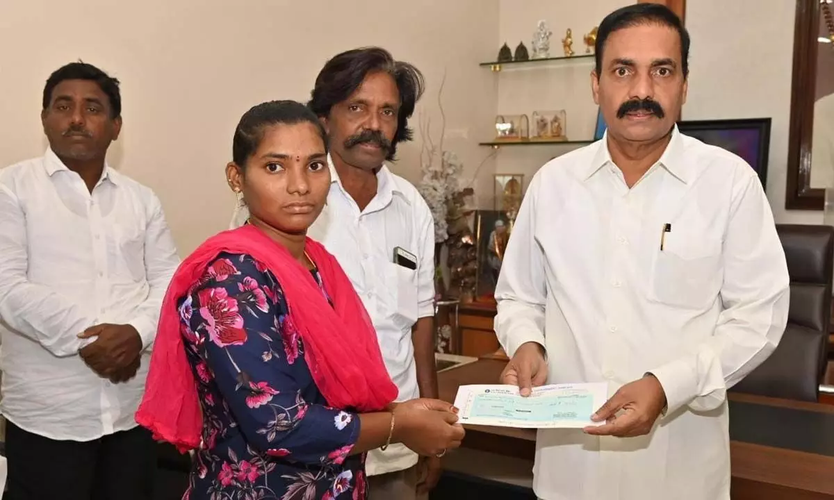 Agriculture Minister Kakani Govardhan Reddy handing over a cheque to a victim at his camp office in Nellore on Saturday