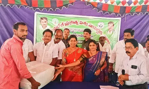 Home Minister Taneti Vanitha and Kovvur Municipal Chairperson B Ratnakumari distributing  fodder to farmers in Kovvuru on Sunday