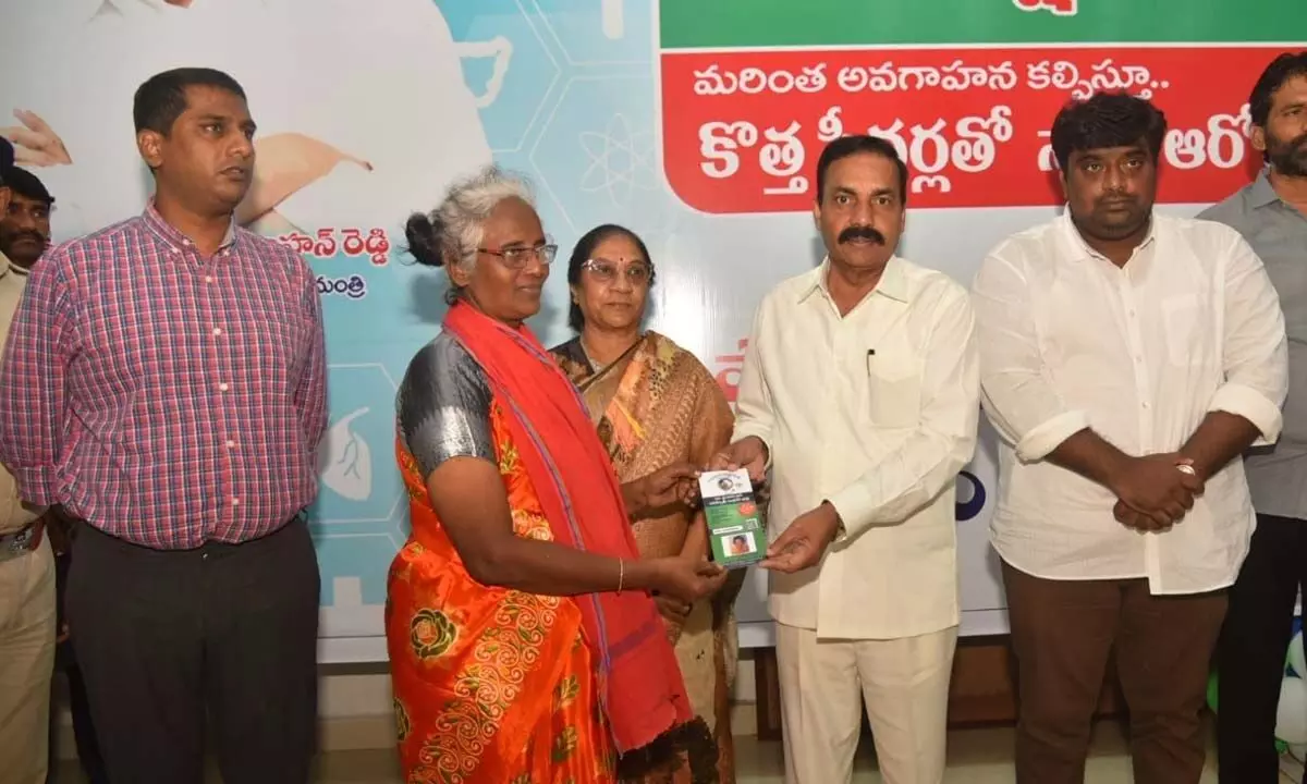 Agriculture Minister Kakani Govardhan Reddy distributing new Aarogyasri smart card to  a beneficiary in Nellore on Monday