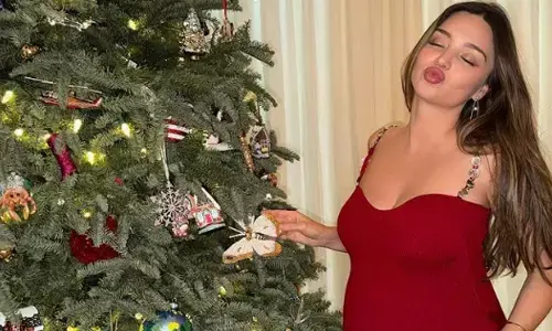 Miranda Kerr flaunts baby bump in festive dress