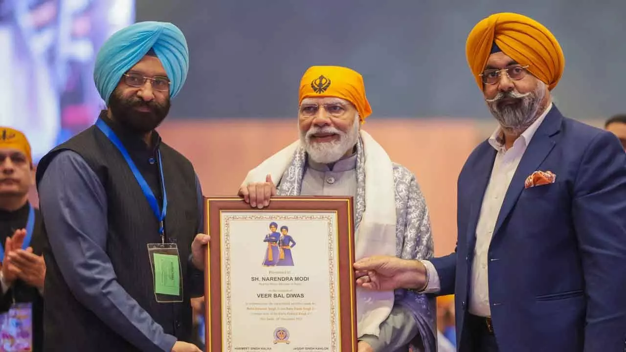 Prime Minister Narendra Modi being felicitated by the Delhi Sikh Gurdwara Management Committee (DSGMC) during Veer Baal Diwas programme commemorating the martyrdom of two sons of Guru Gobind Singh, at Bharat Mandapam, in New Delhi on Tuesday