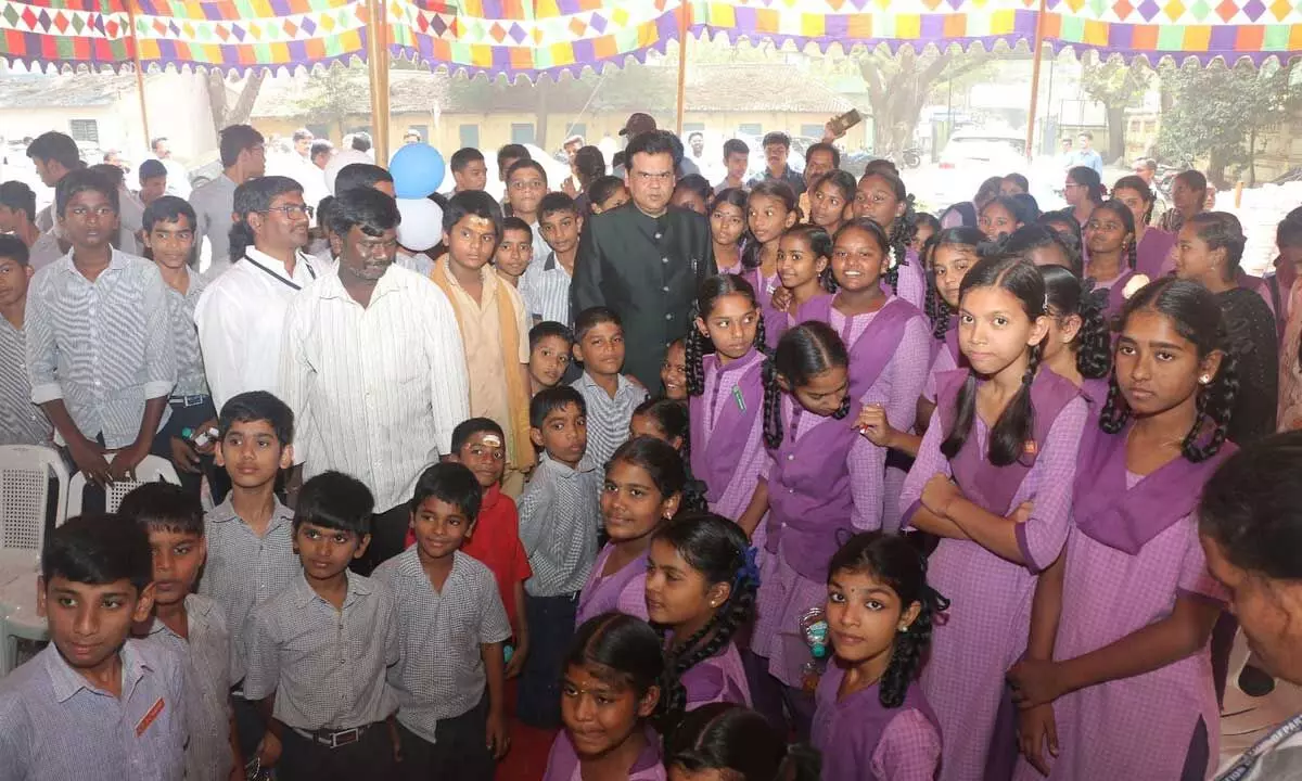 Principal Secretary Praveen Prakash with the students of CVR VMC High School Plus in Vijayawada on Monday