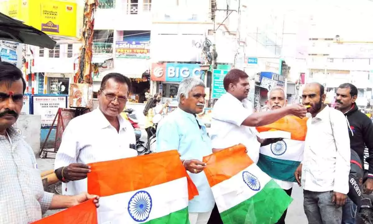 BJP activists distributing sweets to people on the successful launch of PSLV C58 in Tirupati on Monday