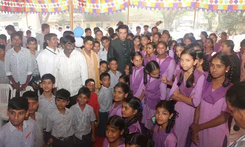Principal Secretary Praveen Prakash with the students of CVR VMC High School Plus in Vijayawada on Monday