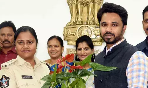 SP Mary Prasanti extending New Year wishes to Collector Prasanna Venkatesh by handing over a flower sapling in Eluru on Monday