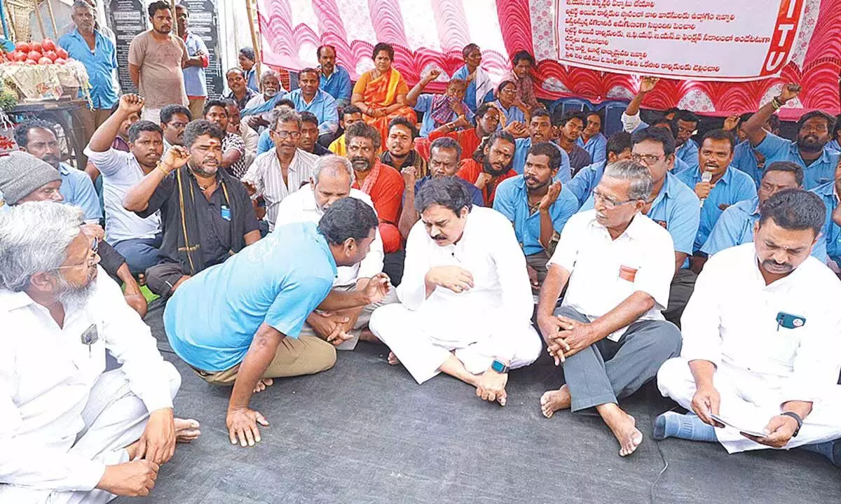 Jana Sena Party leader Nadendla Manohar meets striking sanitation workers at the agitation venue in Tenali on Tuesday