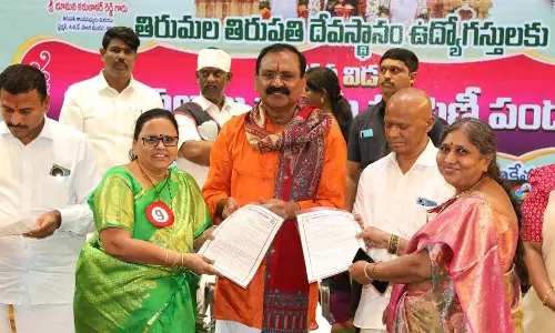 TTD Chairman Bhumana Karunakara Reddy and EO AV Dharma Reddy giving away house site pattas to two employees at Mahati auditorium in Tirupati on Monday
