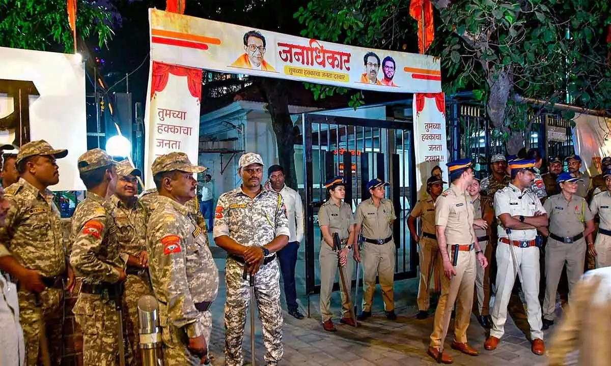 Police personnel stand guard during the celebration of Shiv Sena (Shinde faction) workers after MLAs disqualification verdict, in Mumbai on Wednesday