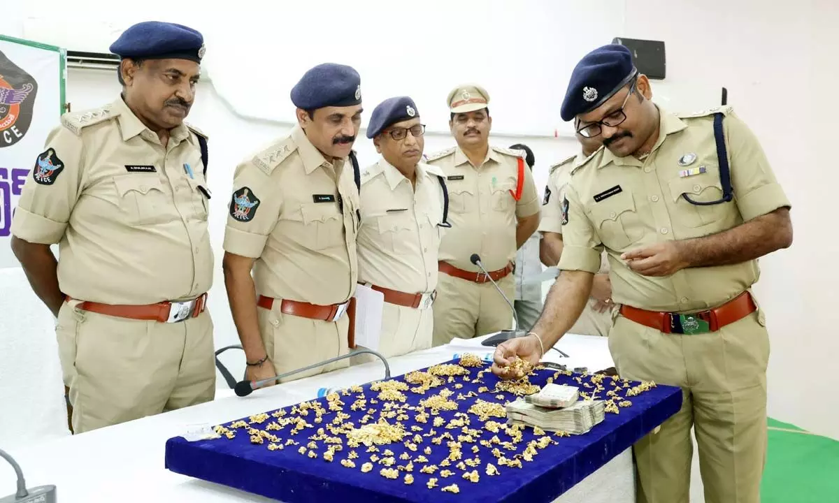 SP Dr K Tirumaleswara Reddy displaying gold ornaments and cash seized from a dacoit gang to the media at Umesh Chandra Meeting Hall in Nellore on Saturday