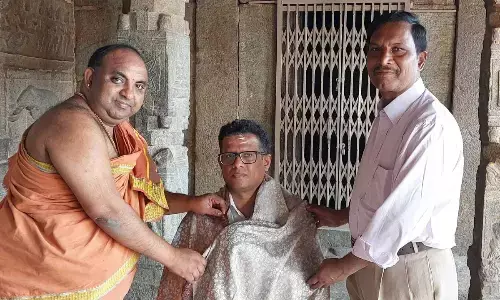 Priest felicitating IREDA National Director Dr Jagannath C Jodidar at Sri Veerabhadra Swamy temple in Lepakshi on Friday. Historian MyNaa Swamy is also seen.