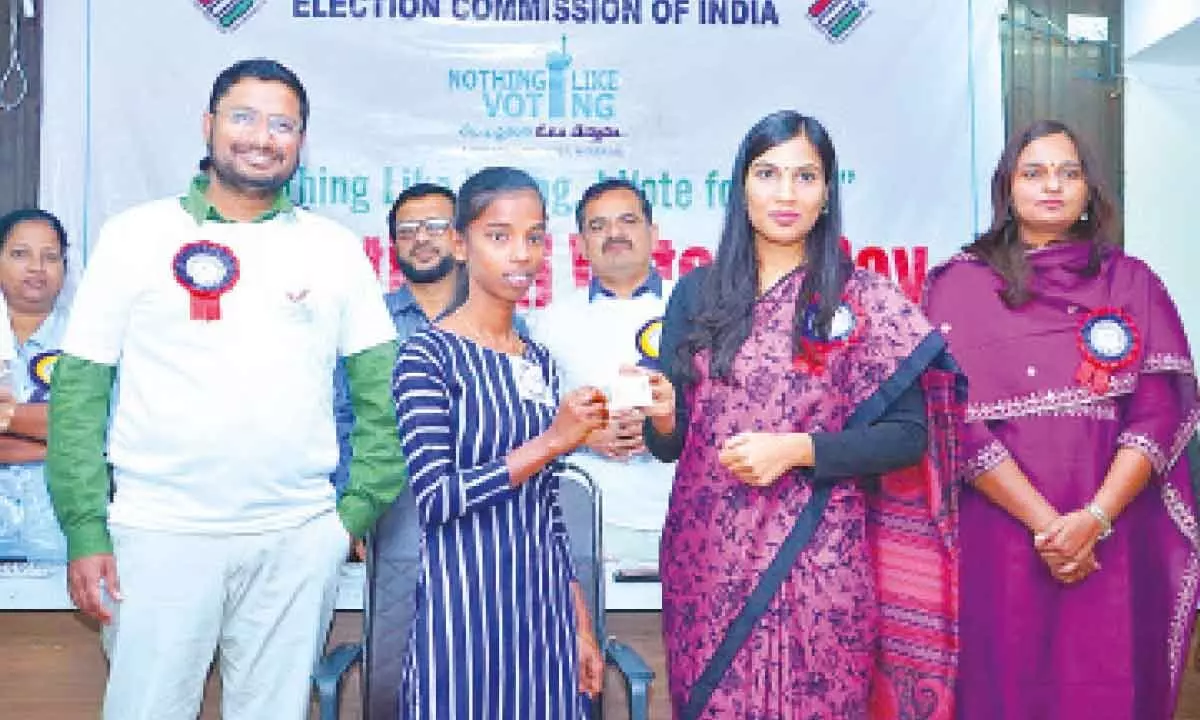 Warangal district collector P Pravinya giving away an EPIC Card to a new voter in Hanumakonda on Thursday