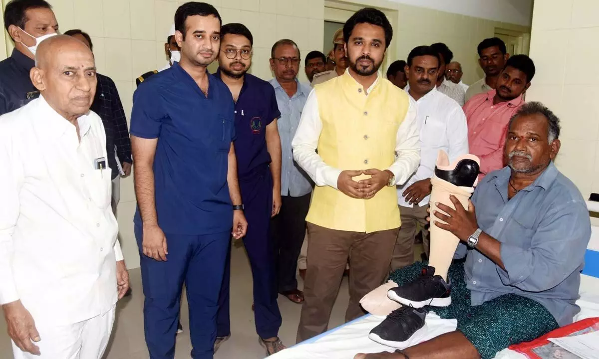 Collector Prasanna Venkatesh with a person in need of artificial limb at the hospital in Dwaraka Tirumala on Friday