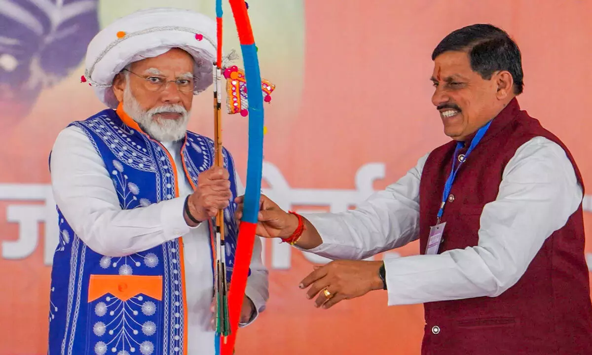Prime Minister Narendra Modi being presented a bow and arrow by Madhya Pradesh Chief Minister Mohan Yadav during the Janjatiya Sammelan in Jhabua, Madhya Pradesh on Sunday