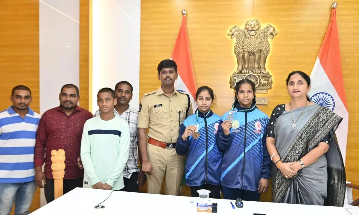 East Godavari District Collector K Madhavi Latha and SP P Jagadeesh congratulating Rajamahendravaram students Karangi Tarangini and Hemasree who won medals in the 67th National School Games