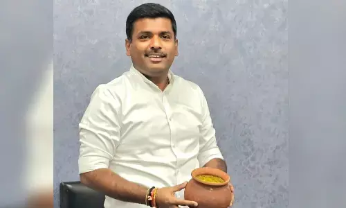 IT Minister Gudivada Amarnath displaying a pot of dal in  Visakhapatnam on Tuesday
