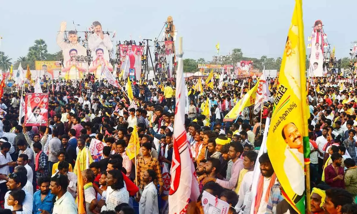 TDP and Jana Sena supporters wave flags during the joint mega meeting at Tadepalligudem on Wednesday night