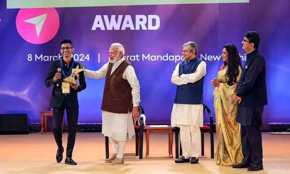 Prime Minister Narendra Modi presents Swachhta Ambassador award to Malhar Kalambe at the National Creators Awards 2024, at Bharat Mandapam in New Delhi on Friday