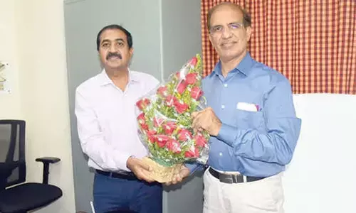 Rajinder Chaudhry, who assumed charge as Additional Director General of Press Information Bureau for AP region, receiving bouquet from PIB Director Dr GD Hallikeri in Vijayawada on Monday