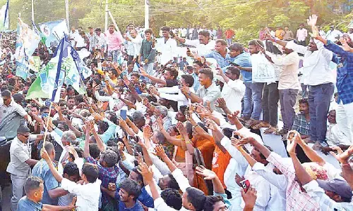 Chief Minister Y S Jagan Mohan Reddy greets people during Memanta Siddham bus yatra in Nandyal on Thursday
