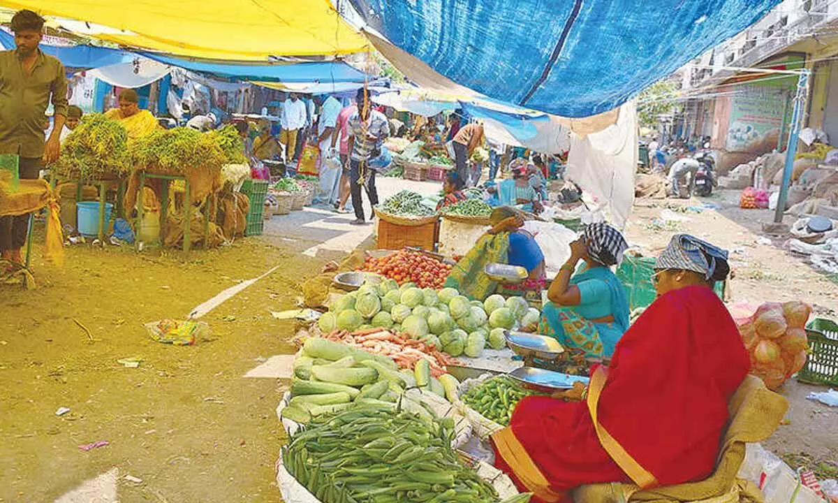 The vegetable vendors in Monda market set up plastic sheets as roofs to escape from scorching heat on Sunday.Photo: Srinivas Setty