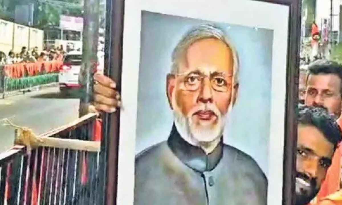 Modi accepts his portrait by local artist during Mangaluru road show