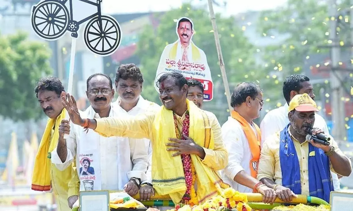 Alliance candidate Palla Srinivasa Rao waving at people during his campaign held in Gajuwaka