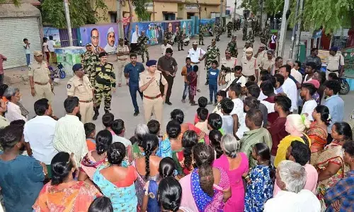 SP Amit Bardar interacting with residents in Ambedkar Nagar in Anantapur on Thursday during flag march