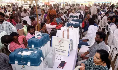 Polling staff with EVMs and polling material waiting to leave distribution centre in Eluru on Sunday