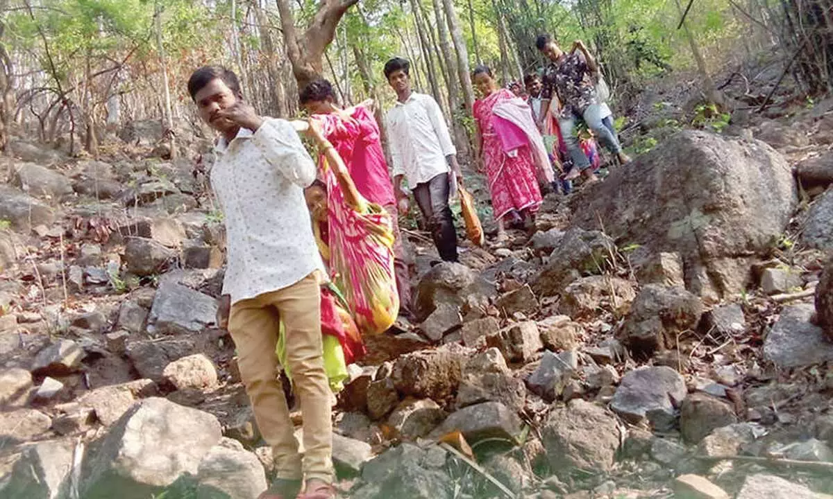 Tribals carrying an old man in a doli to a polling station from Rompalli panchayat in Anantgiri mandal
