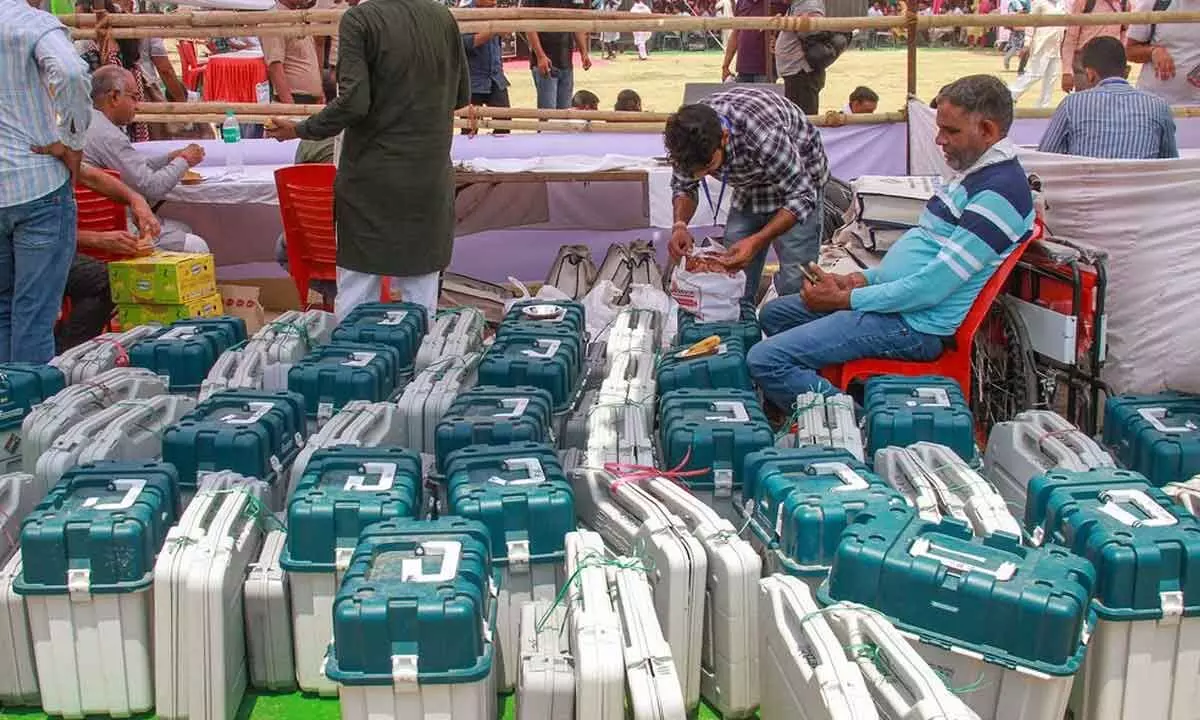 Polling officials check EVMs before leaving for their respective polling booths, on the eve of the sixth phase of Lok Sabha polls, in Gurugram on Friday