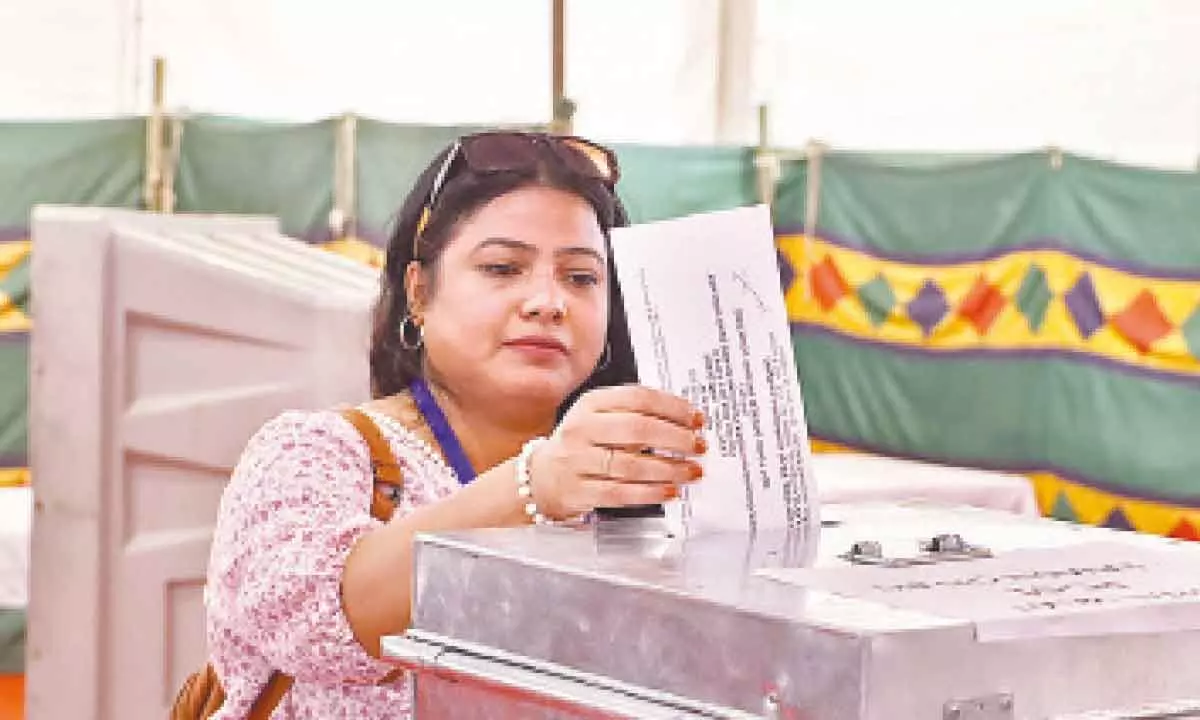 A government officer on election duty casts her vote at a distribution center at Gole Market on the eve of the sixth phase of Lok Sabha polls, in New Delhi on Friday
